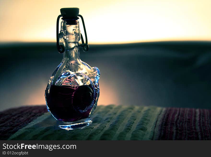 A small glass bottle on a smooth background. A small glass bottle on a smooth background