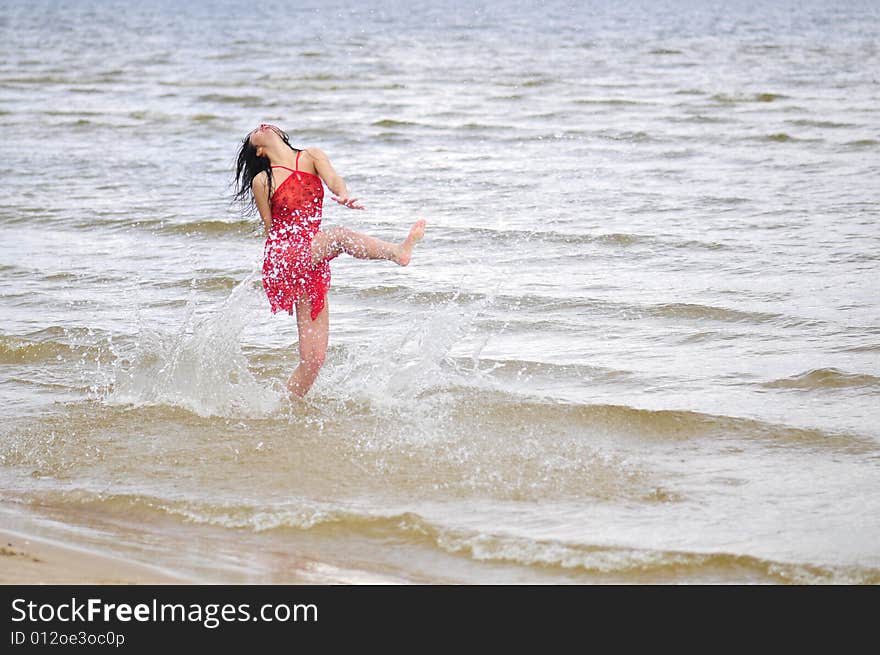 Beautiful happy woman dancing on the beach