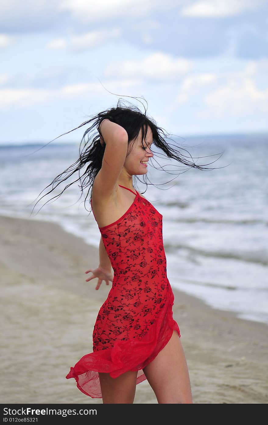 Beautiful happy woman dancing on the beach