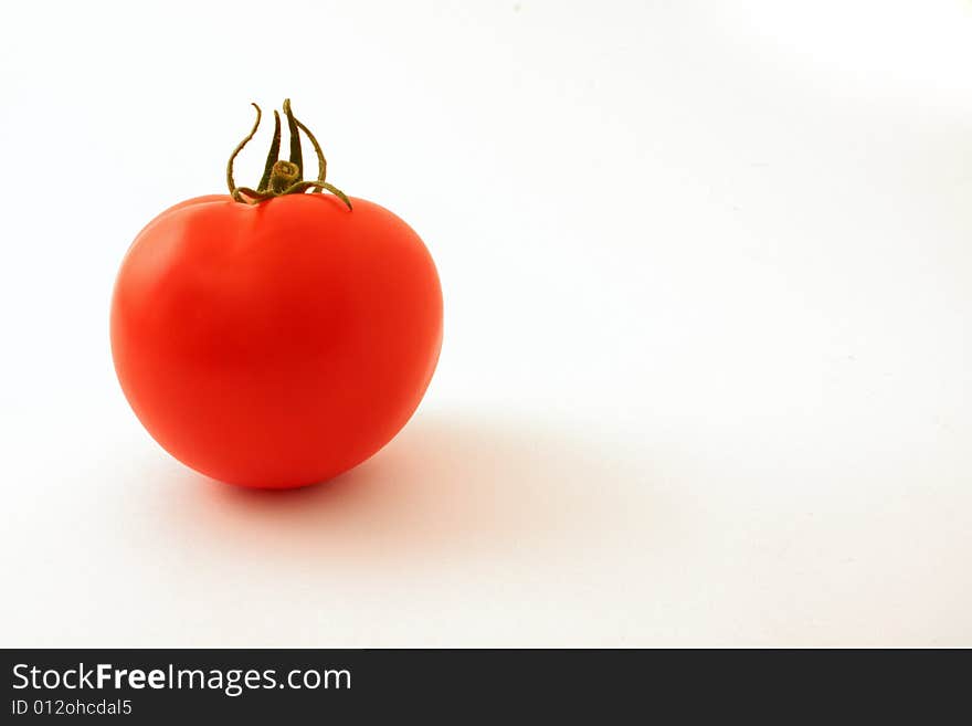 Single tomato set against a white backdrop. Single tomato set against a white backdrop