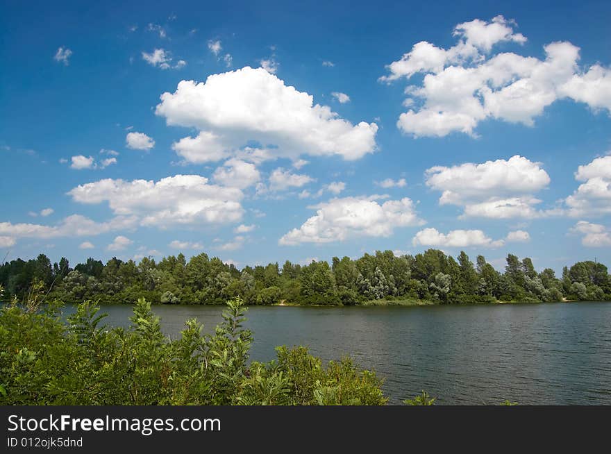 Summer landscape with trees, sky and river