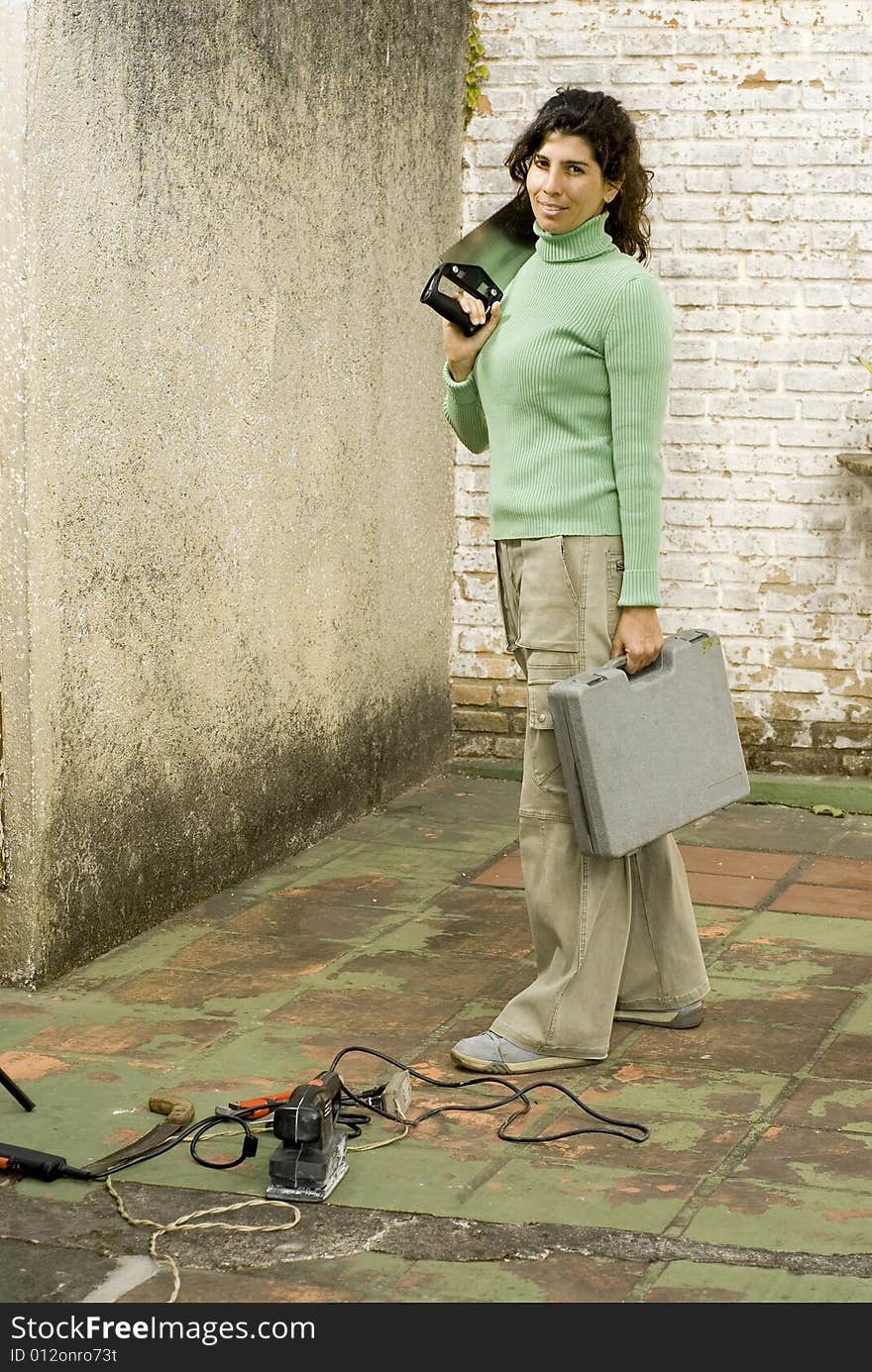 Woman Holding Saw and Toolkit - Vertical