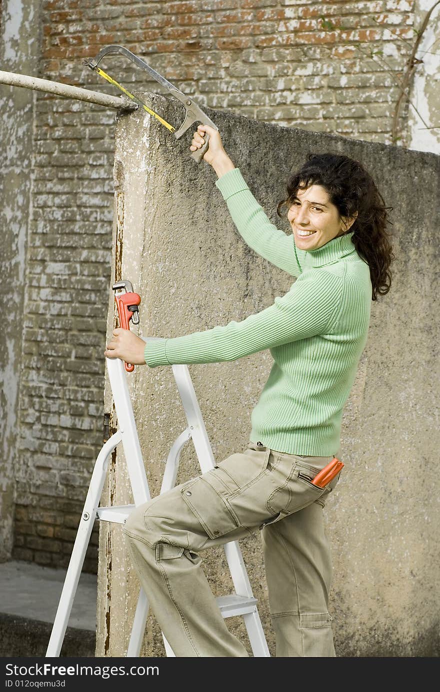 Smiling woman using tools. Vertically framed photo. Smiling woman using tools. Vertically framed photo.