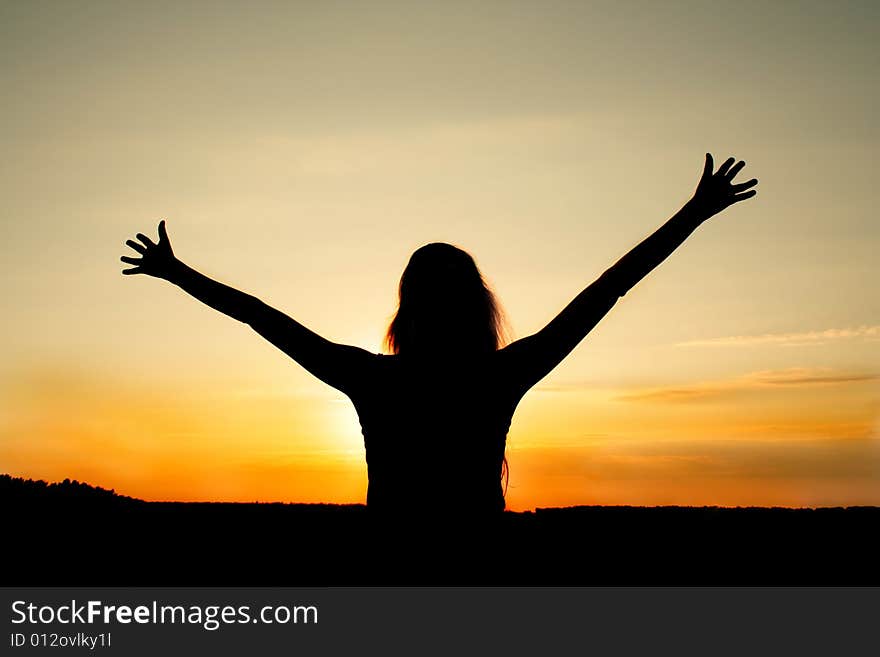 Dark silhouette of the pleased girl on a background of a decline. Dark silhouette of the pleased girl on a background of a decline