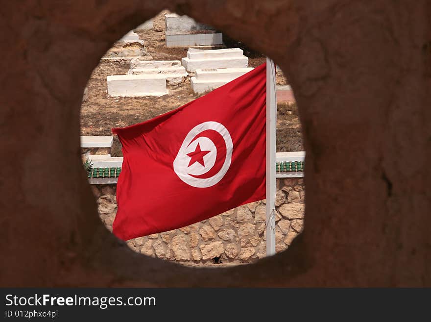 Tunisian flag with the cemetery background seen from ribat in Monastir, Tunisia