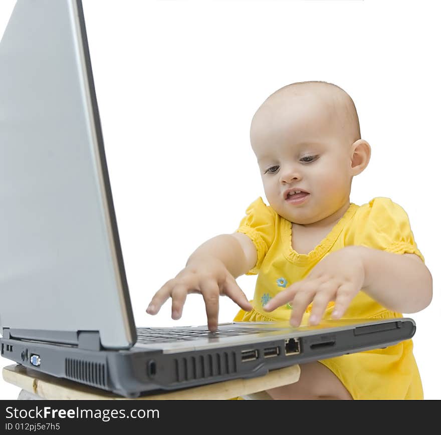 Little baby girl in yellow playing with laptop. Little baby girl in yellow playing with laptop