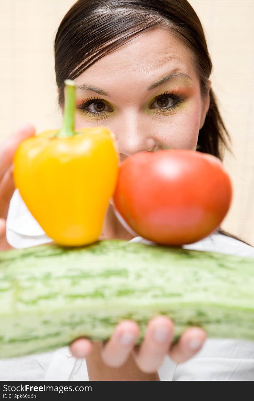 Attractive brunette woman holding vegetable. Attractive brunette woman holding vegetable