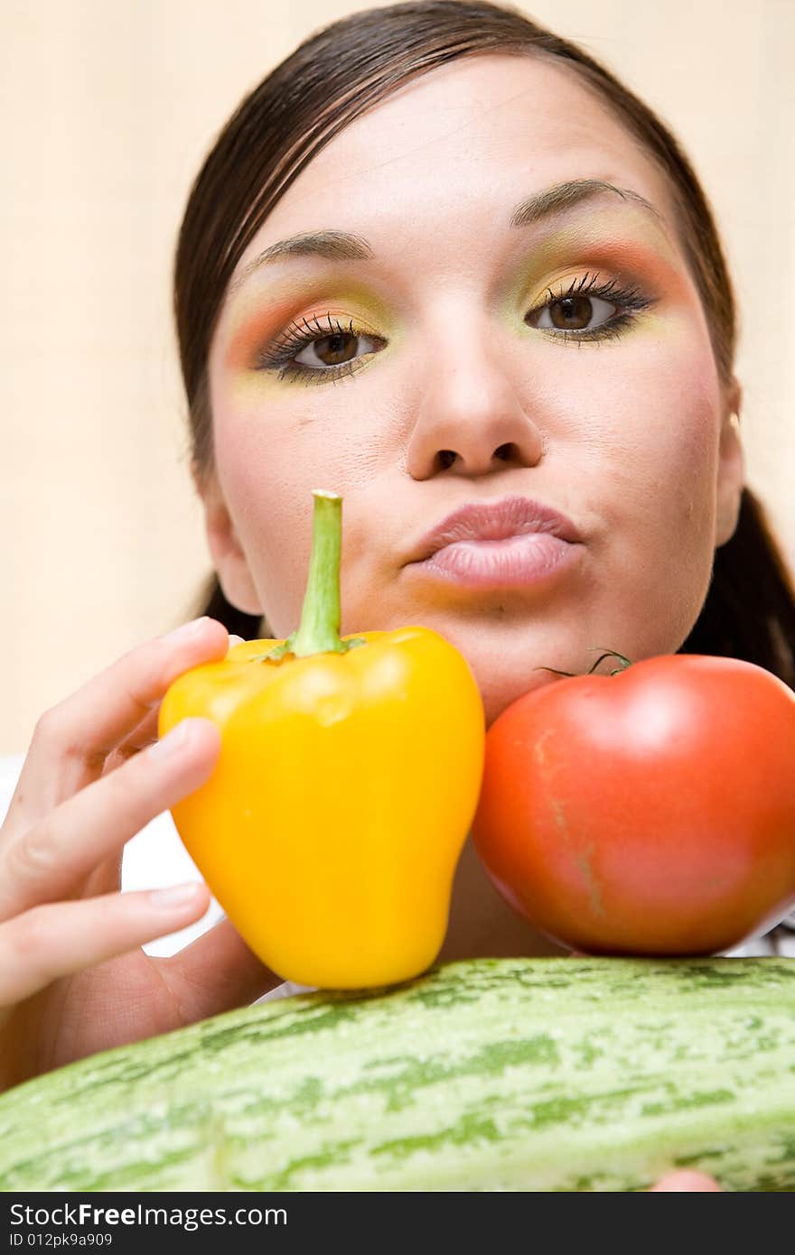 Attractive brunette woman holding vegetable. Attractive brunette woman holding vegetable