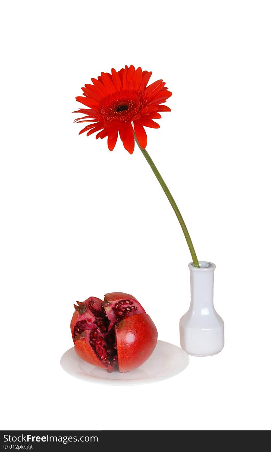 Red flower and pomegranate on a table