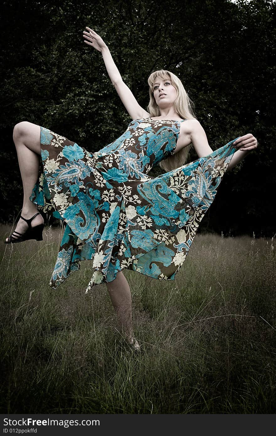 Young blond woman wearing a dress in the forest. Young blond woman wearing a dress in the forest