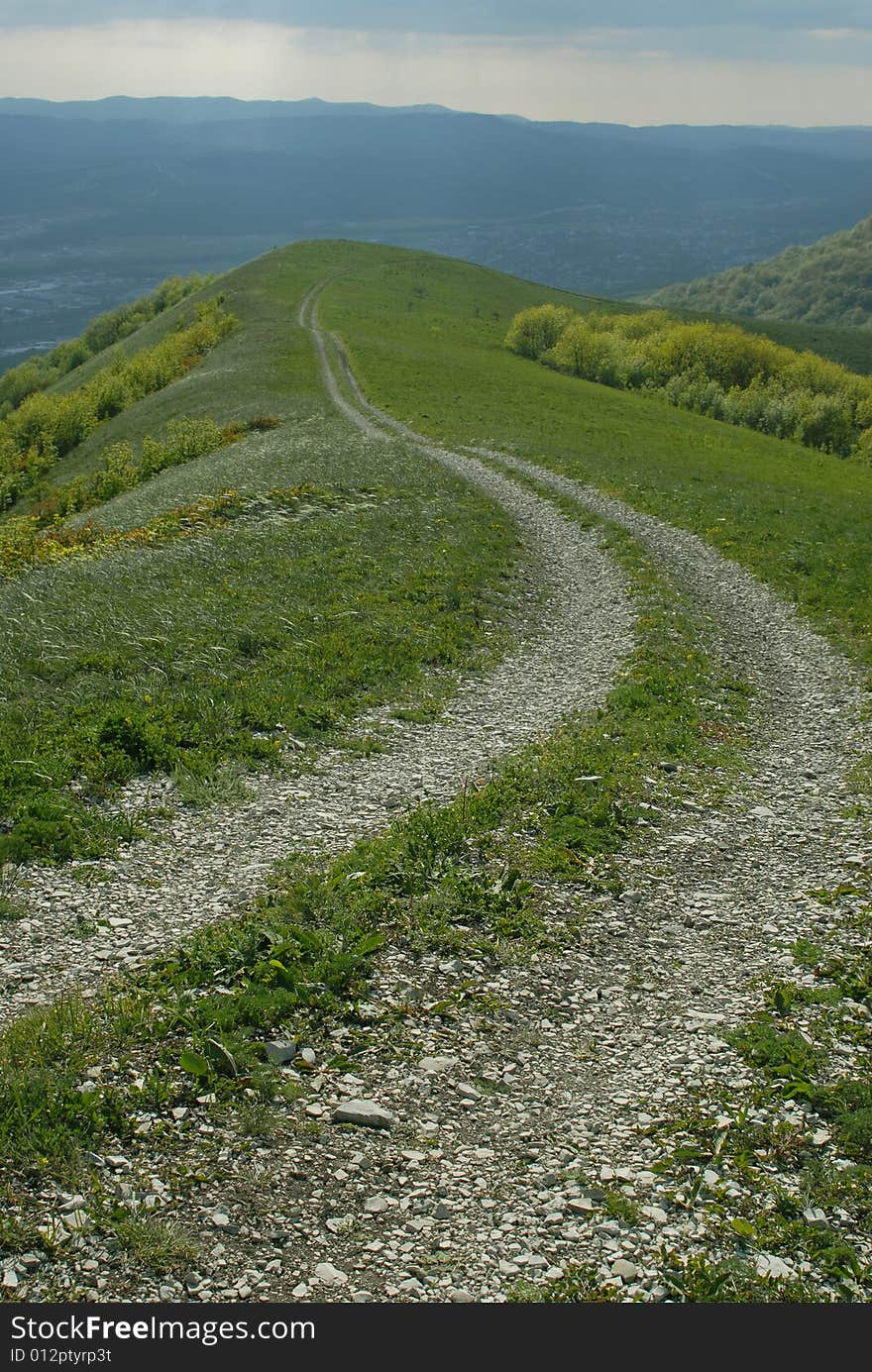 Caucasian gravel road and sunrays in the skay. Caucasian gravel road and sunrays in the skay.