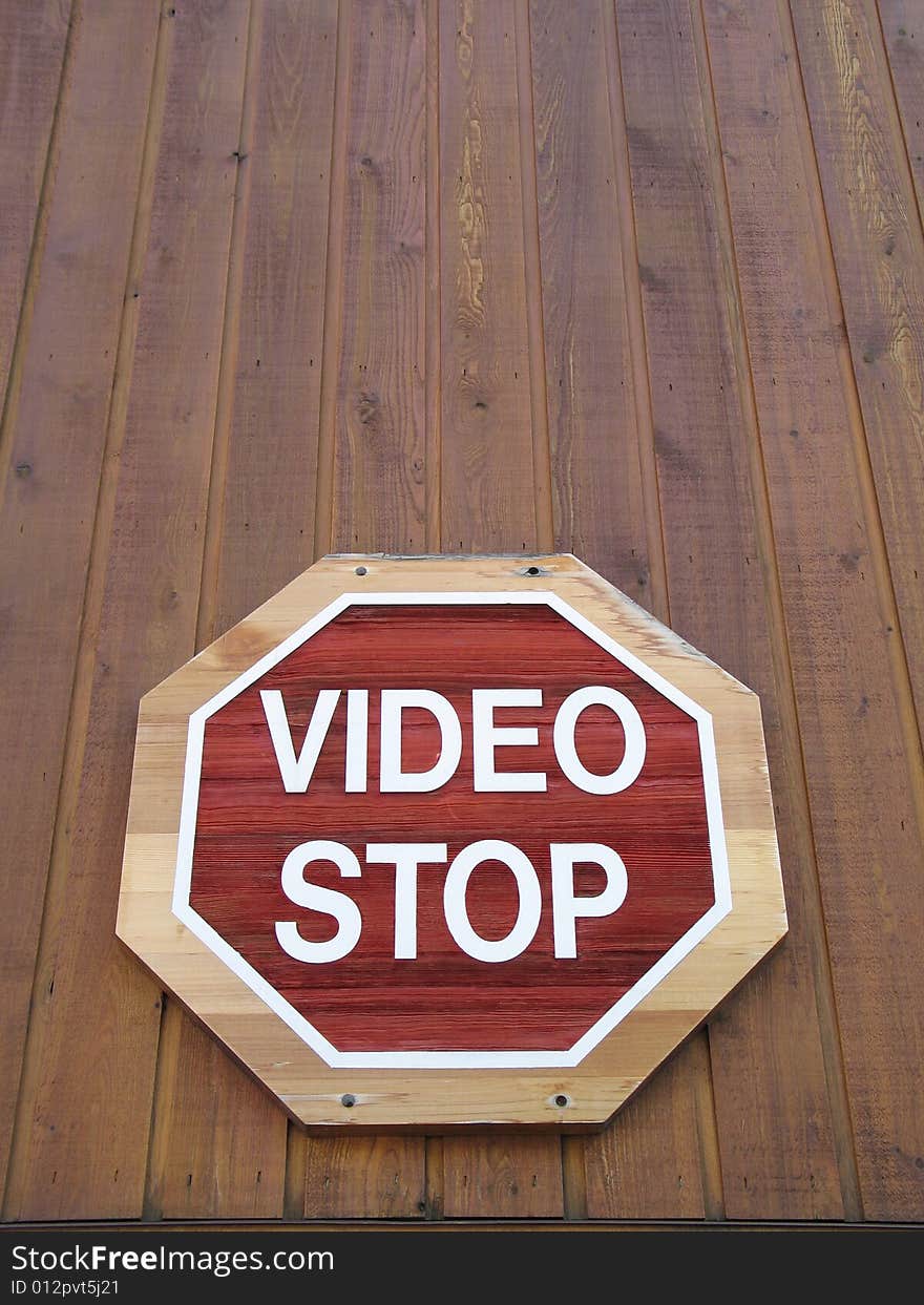 Red video stop sign on a brown wood wall