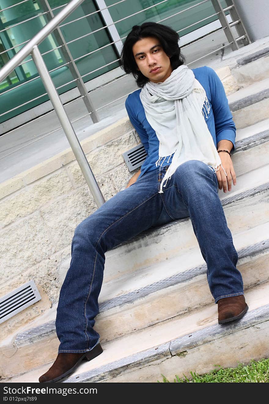 Trendy Young male sitting on a set of stairs. Trendy Young male sitting on a set of stairs.