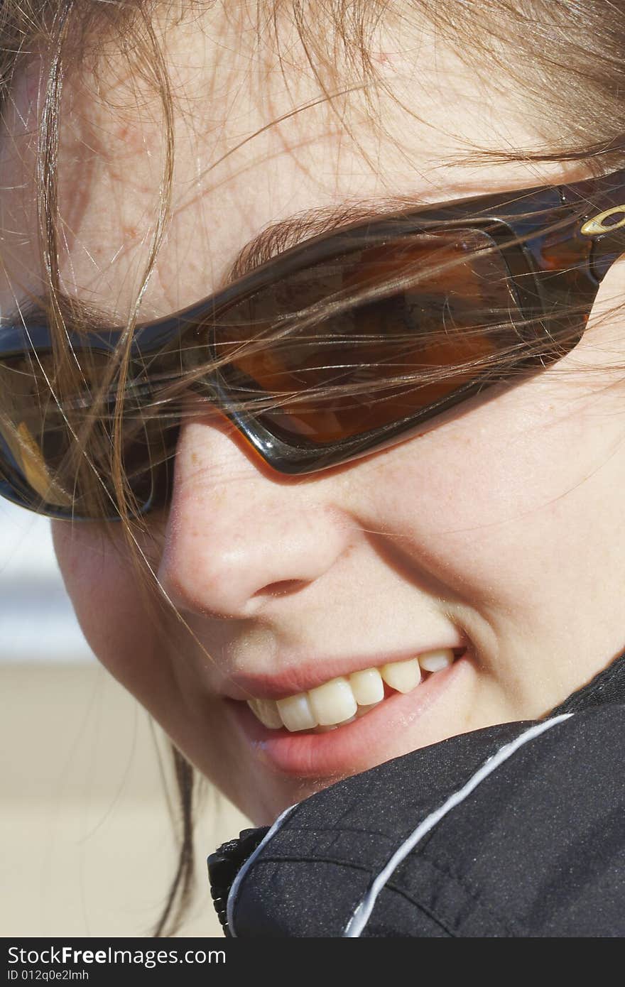 Close-up shot of beautiful young happy girl with sunglasses looking back over shoulder. Close-up shot of beautiful young happy girl with sunglasses looking back over shoulder