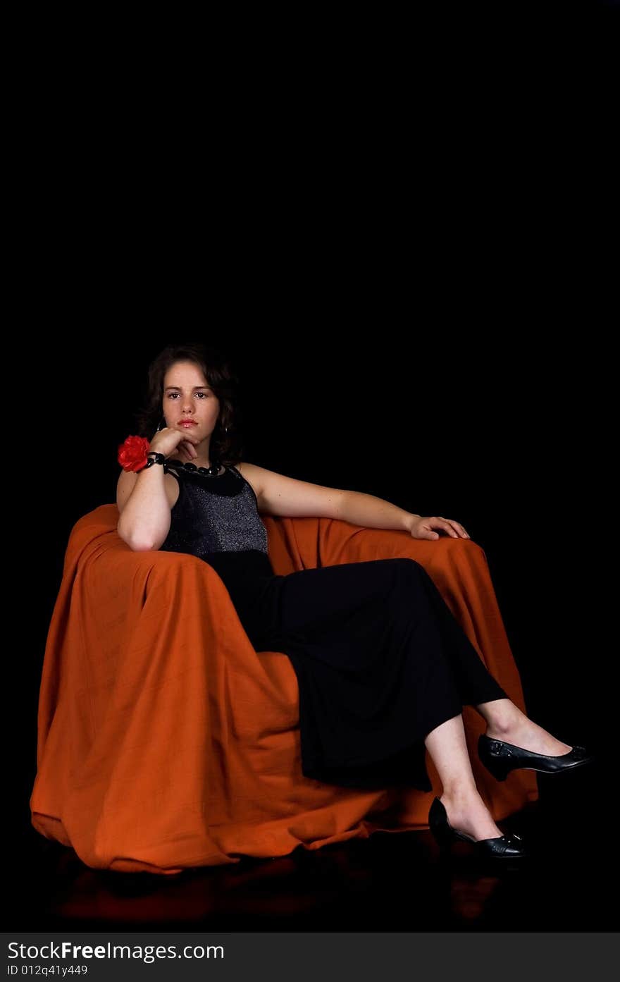 Glamorous young lady with black dress on black background, studio shot