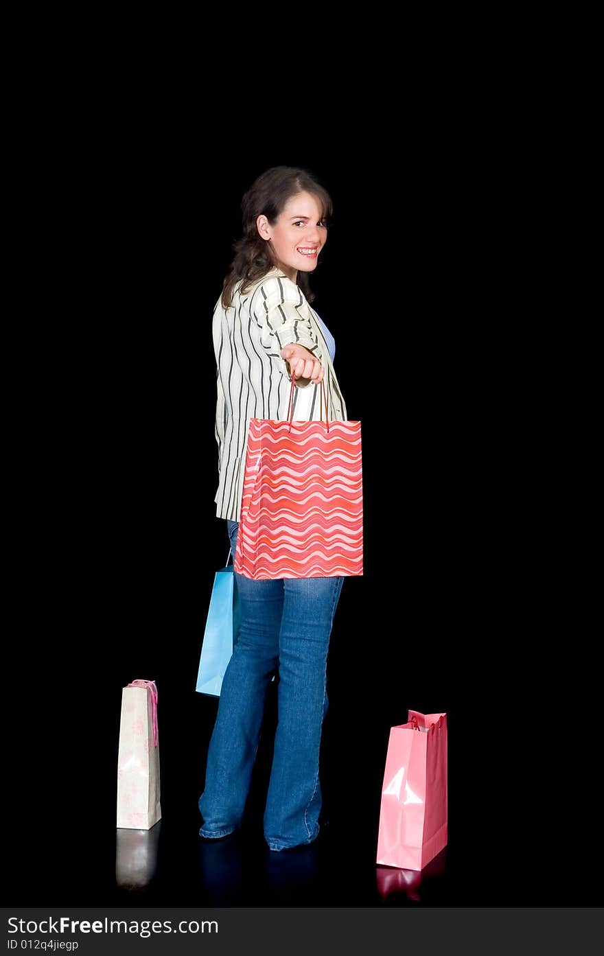 Happy young woman with shopping bags, black background, studio shot. Happy young woman with shopping bags, black background, studio shot