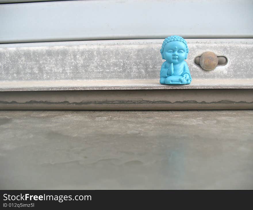 Little blue buddha figurine on a window sill. Horizontally framed photo. Little blue buddha figurine on a window sill. Horizontally framed photo.