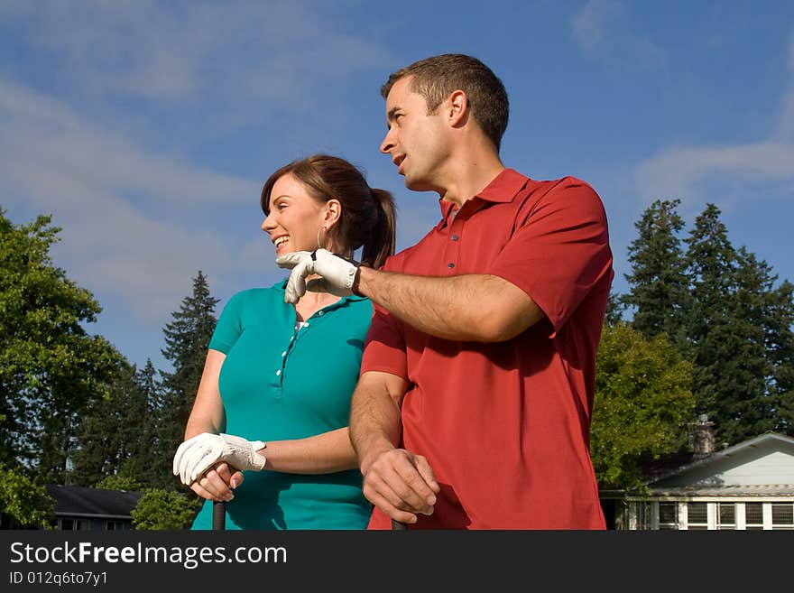 Golfers stand in front of camera. Man is pointing into the distance. Horizontally framed photo. Golfers stand in front of camera. Man is pointing into the distance. Horizontally framed photo.