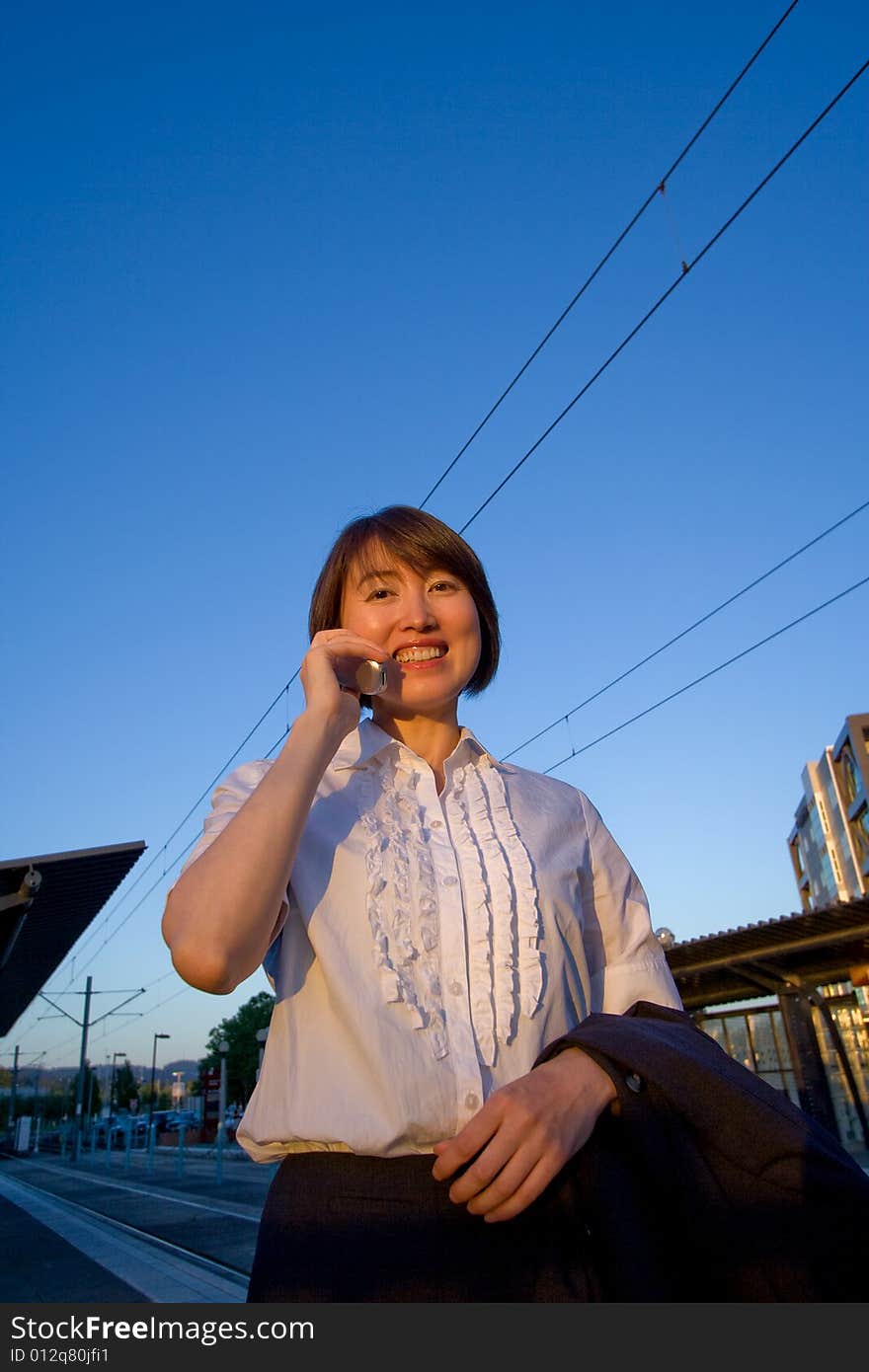 Woman on Cellphone Smiles at Camera - Vertical