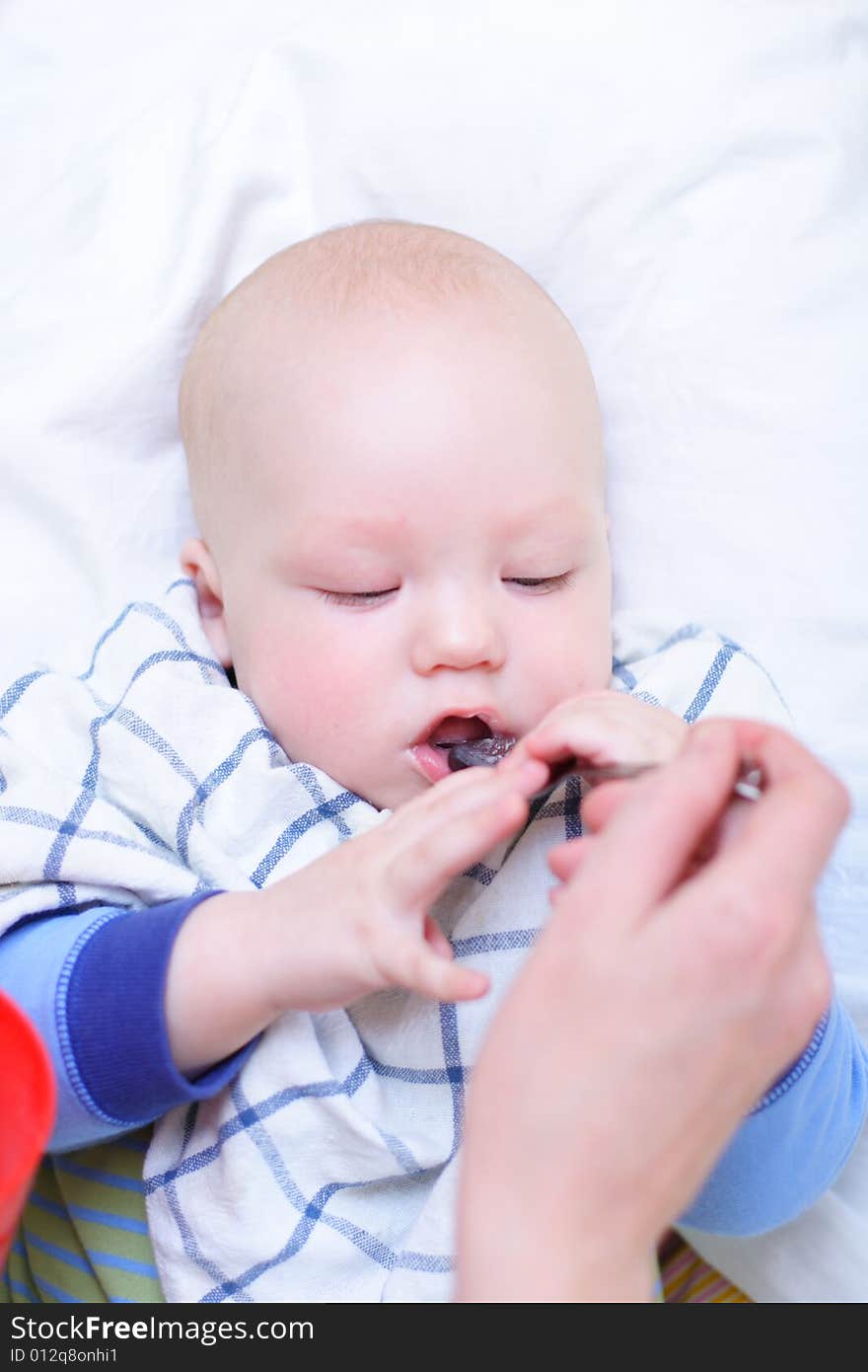 Mother feeding her baby by spoon. Mother feeding her baby by spoon