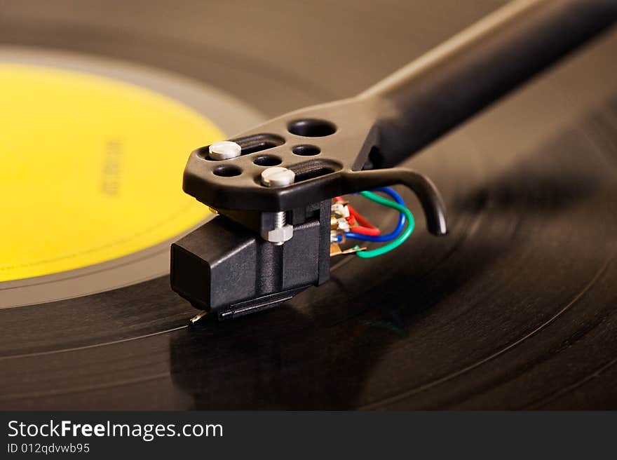 Close-up image of a turntable showing details of the cartridge and tonearm