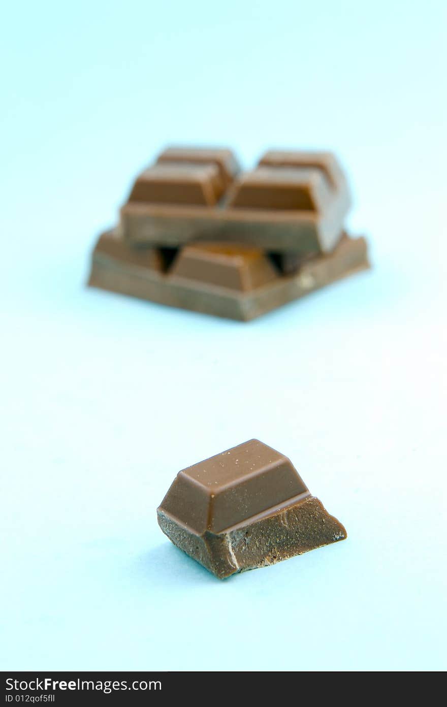 Milk chocolate isolated against a blue background