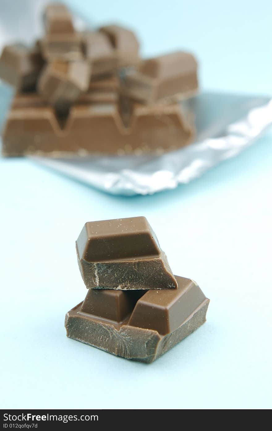 Milk chocolate isolated against a blue background