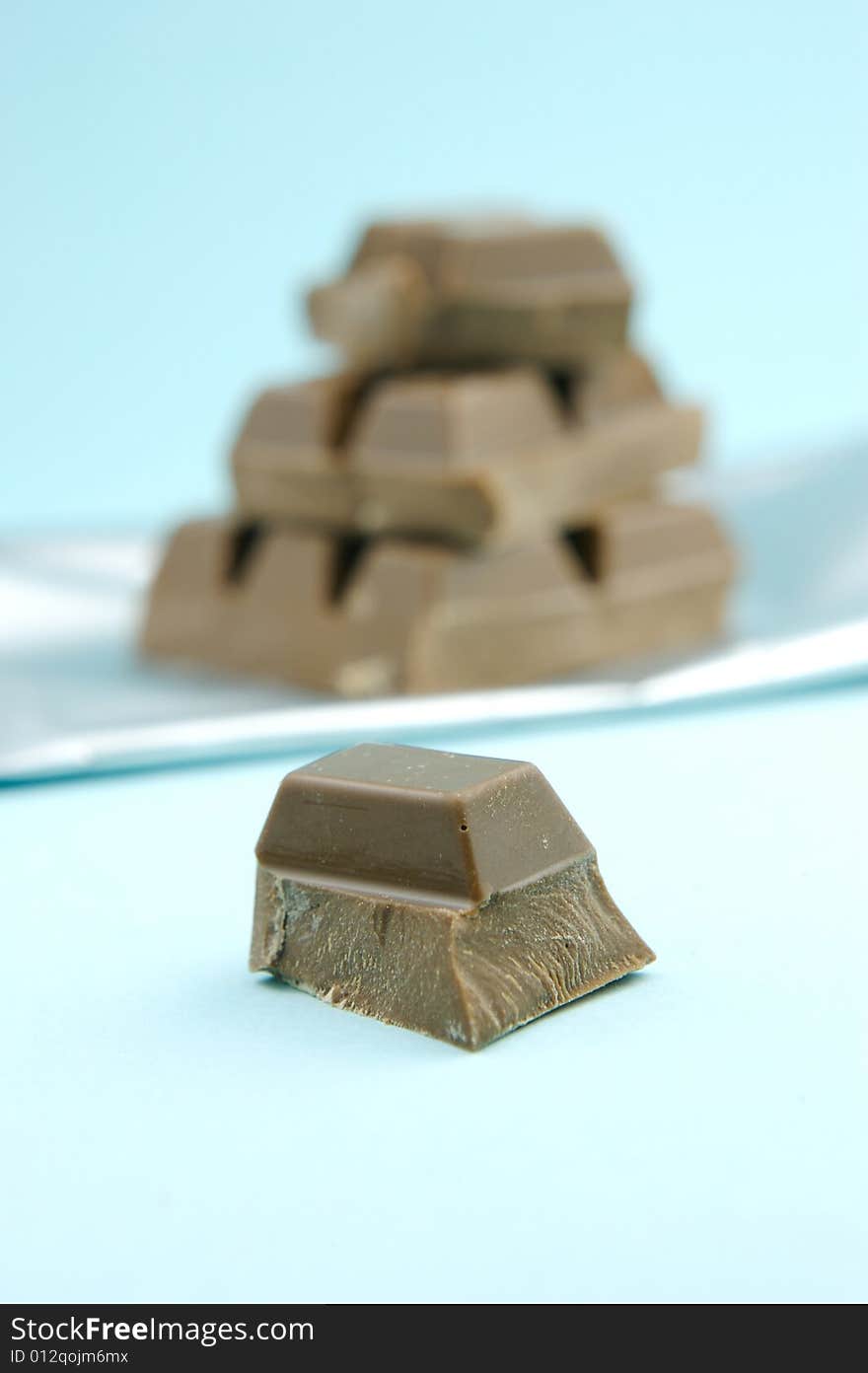 Milk chocolate isolated against a blue background