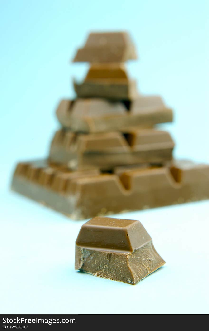 Milk chocolate isolated against a blue background