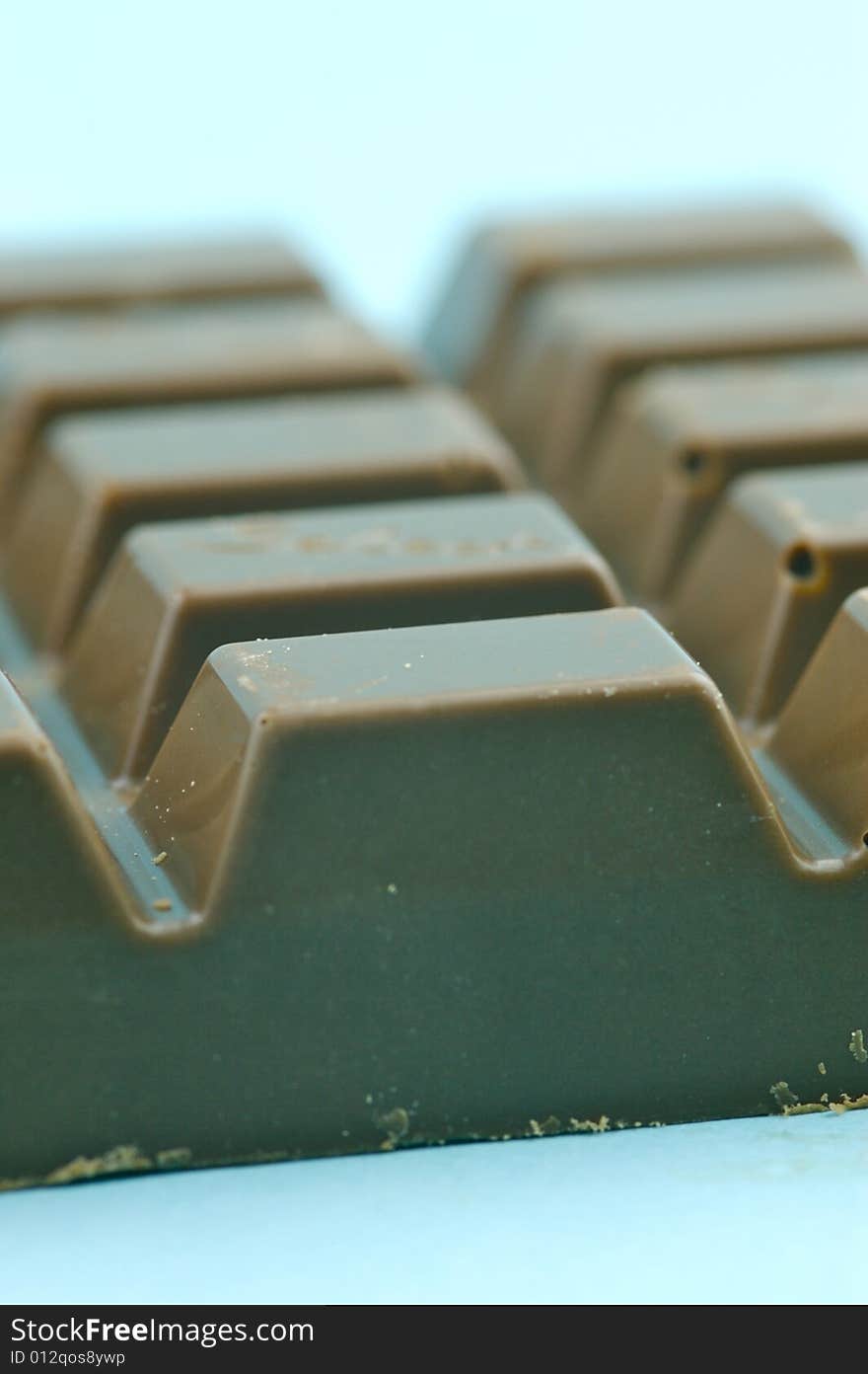 Milk chocolate isolated against a blue background