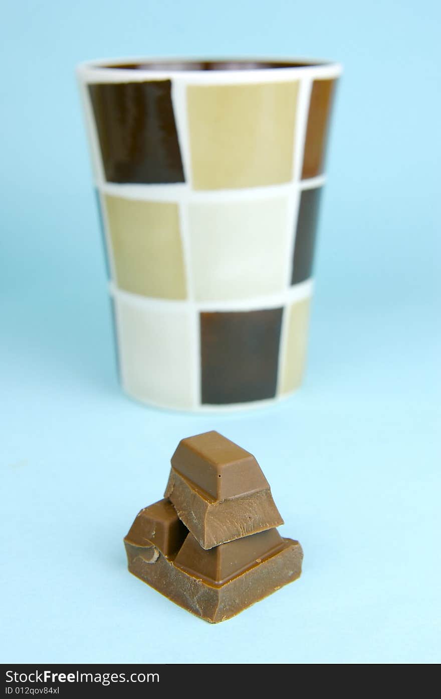 Milk chocolate isolated against a blue background. Milk chocolate isolated against a blue background