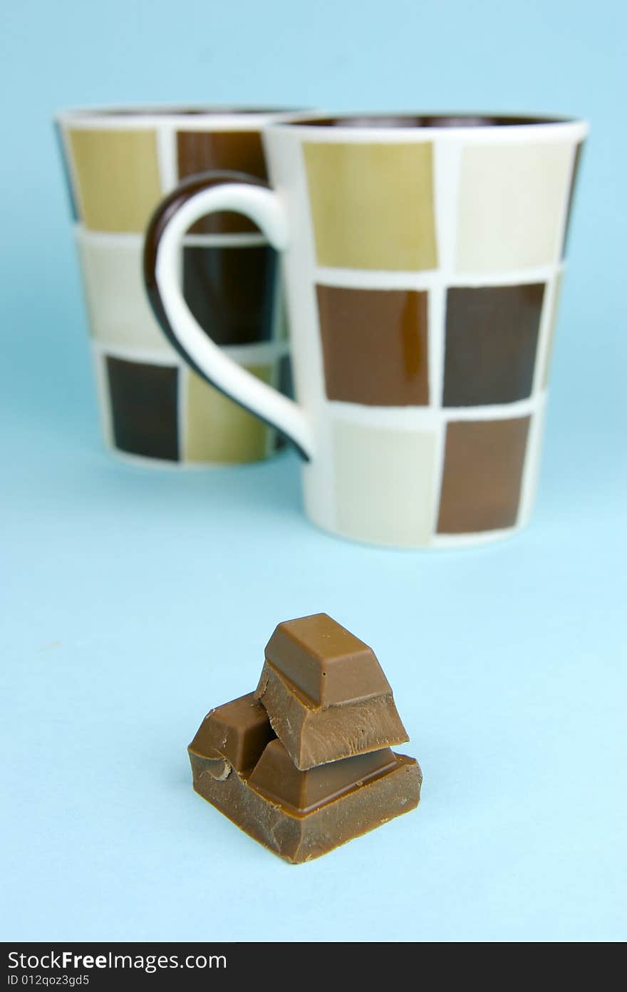 Milk chocolate isolated against a blue background. Milk chocolate isolated against a blue background