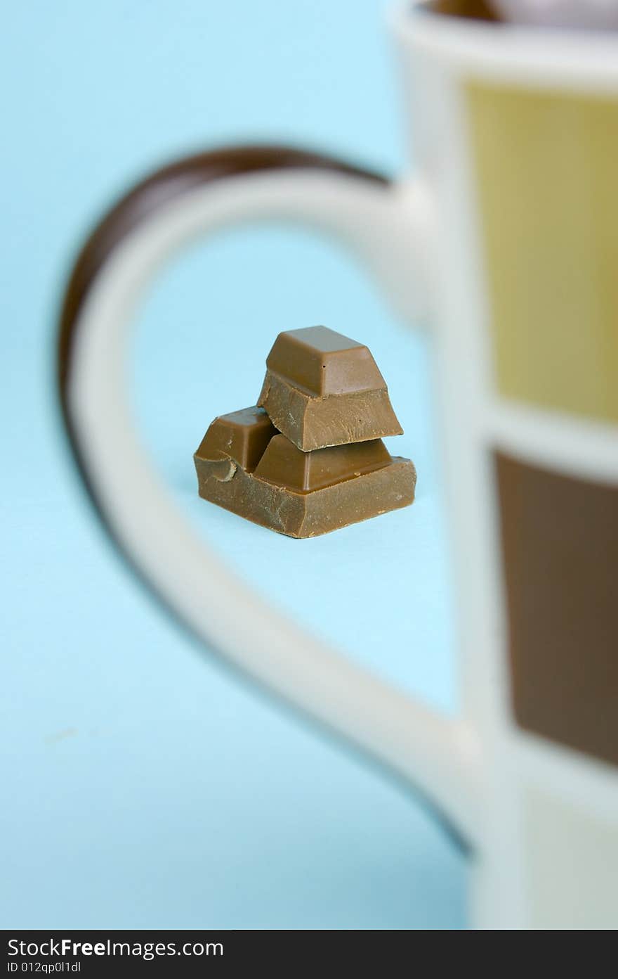 Milk chocolate isolated against a blue background. Milk chocolate isolated against a blue background