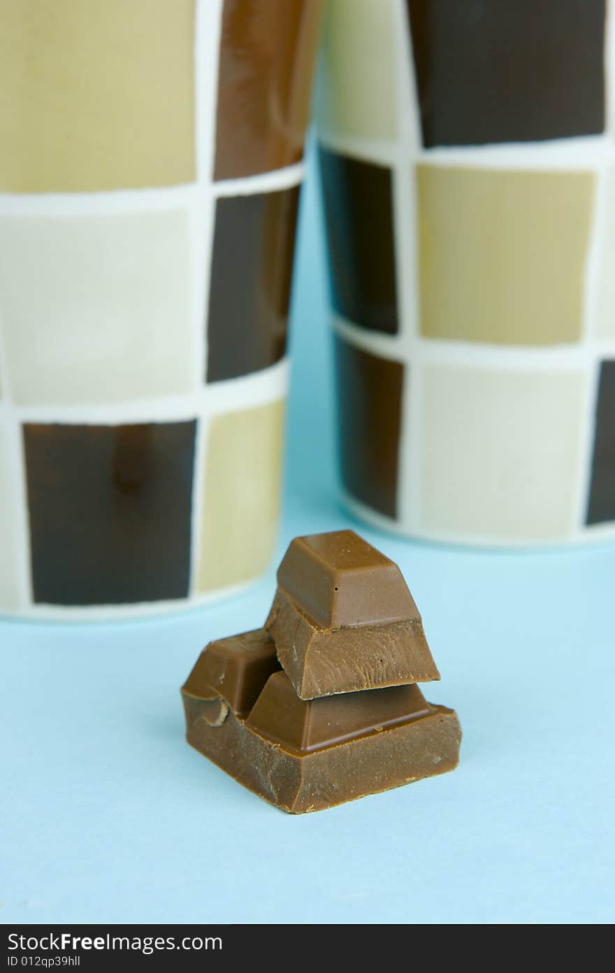 Milk chocolate isolated against a blue background. Milk chocolate isolated against a blue background