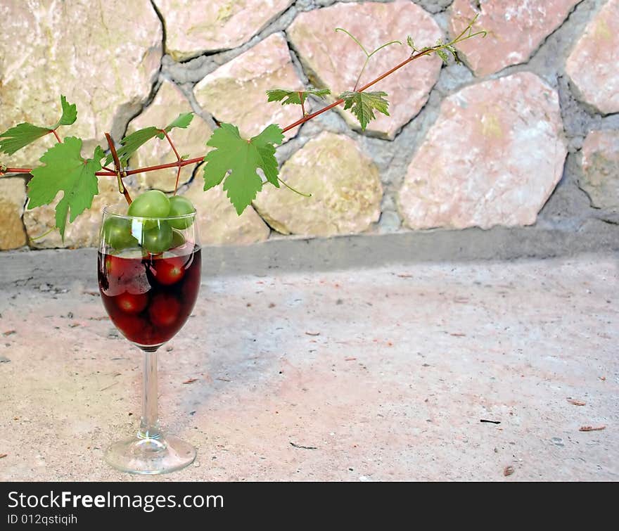 wineglass with red wine and green grapes cluster. wineglass with red wine and green grapes cluster