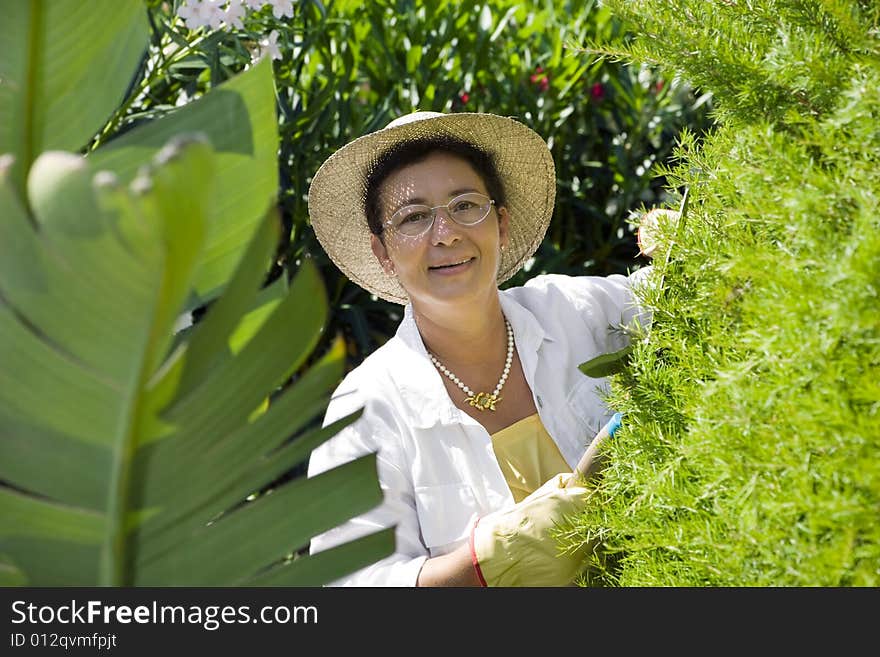 Portrait of senior Italian woman gardening, looking at camera