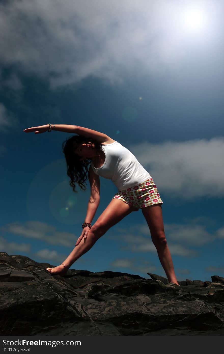 A beautiful woman doing yoga to show a healthy way to live a happy and relaxed lifestyle in a world full of stress. A beautiful woman doing yoga to show a healthy way to live a happy and relaxed lifestyle in a world full of stress