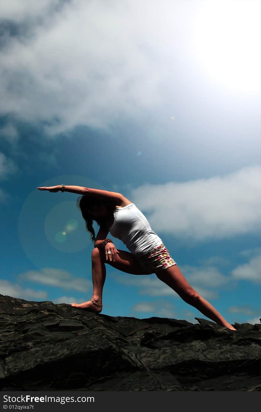 A beautiful woman doing yoga to show a healthy way to live a happy and relaxed lifestyle in a world full of stress. A beautiful woman doing yoga to show a healthy way to live a happy and relaxed lifestyle in a world full of stress