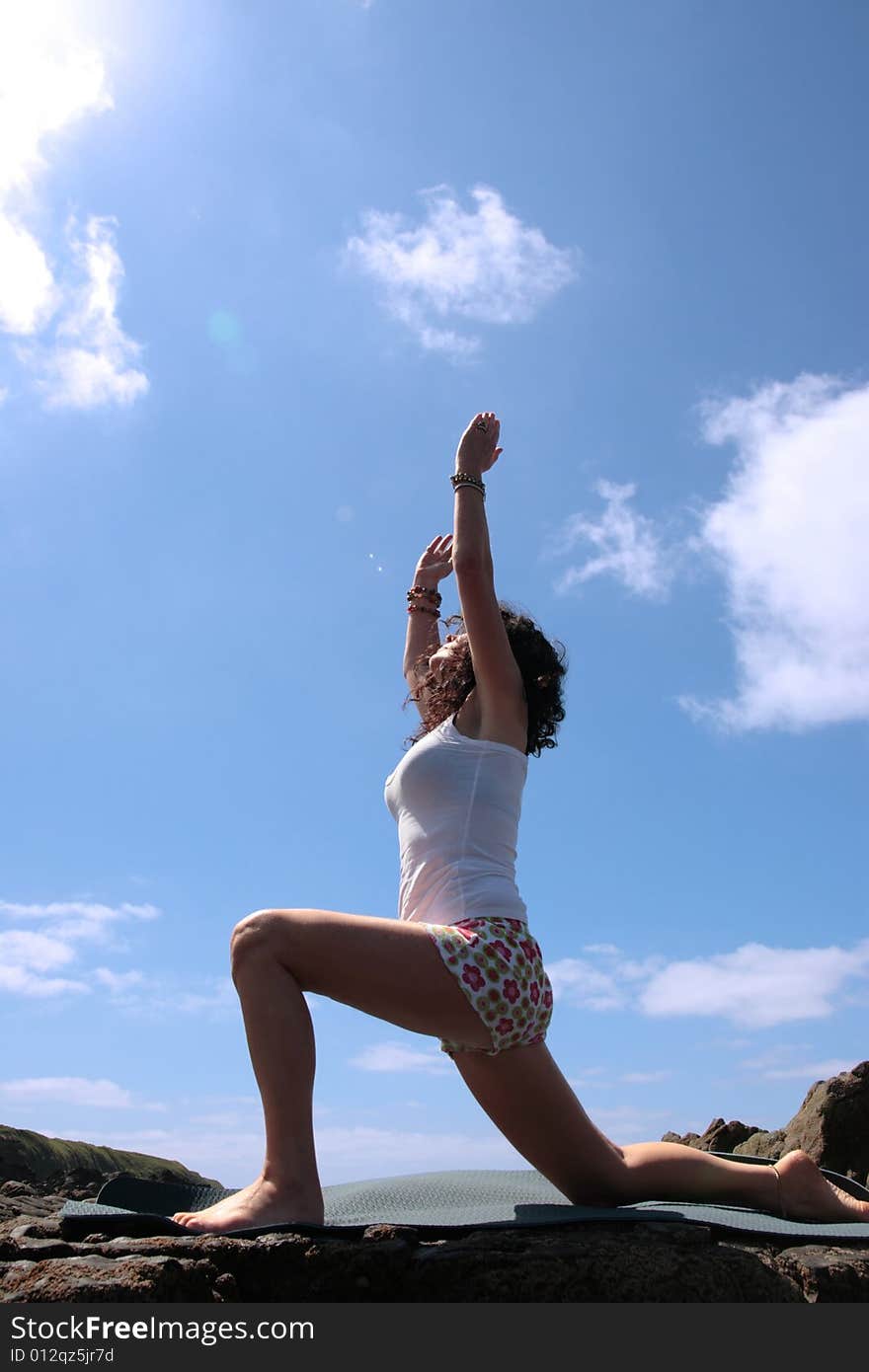 A beautiful woman doing yoga to show a healthy way to live a happy and relaxed lifestyle in a world full of stress. A beautiful woman doing yoga to show a healthy way to live a happy and relaxed lifestyle in a world full of stress