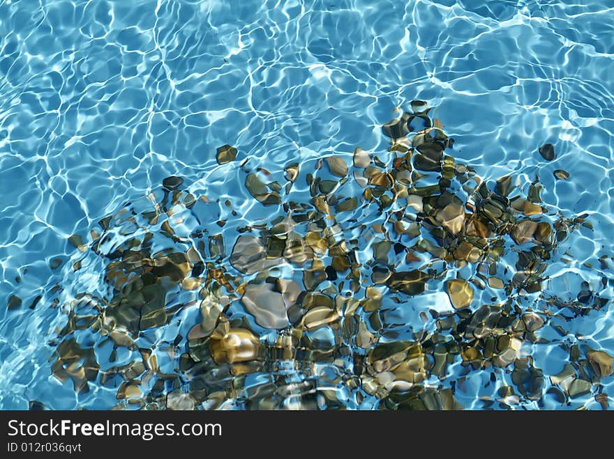 Transparent blue water with stone