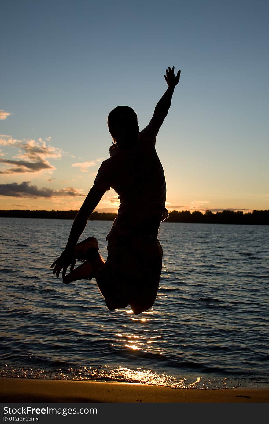 Young man jump over sunlight near the river