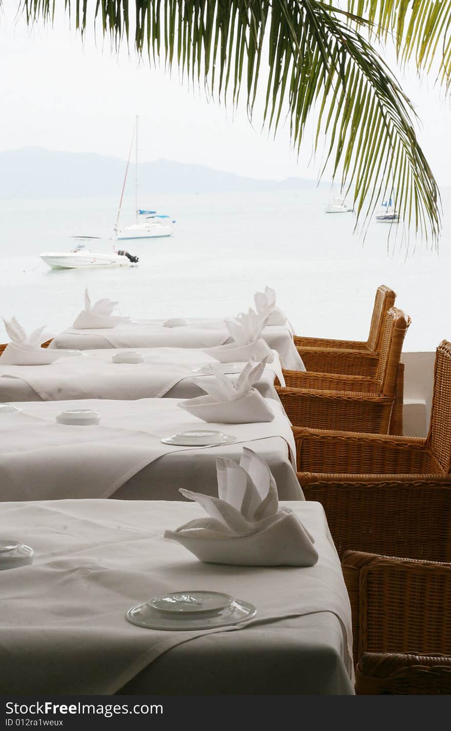 Elegant white table setting overlooking the ocean.