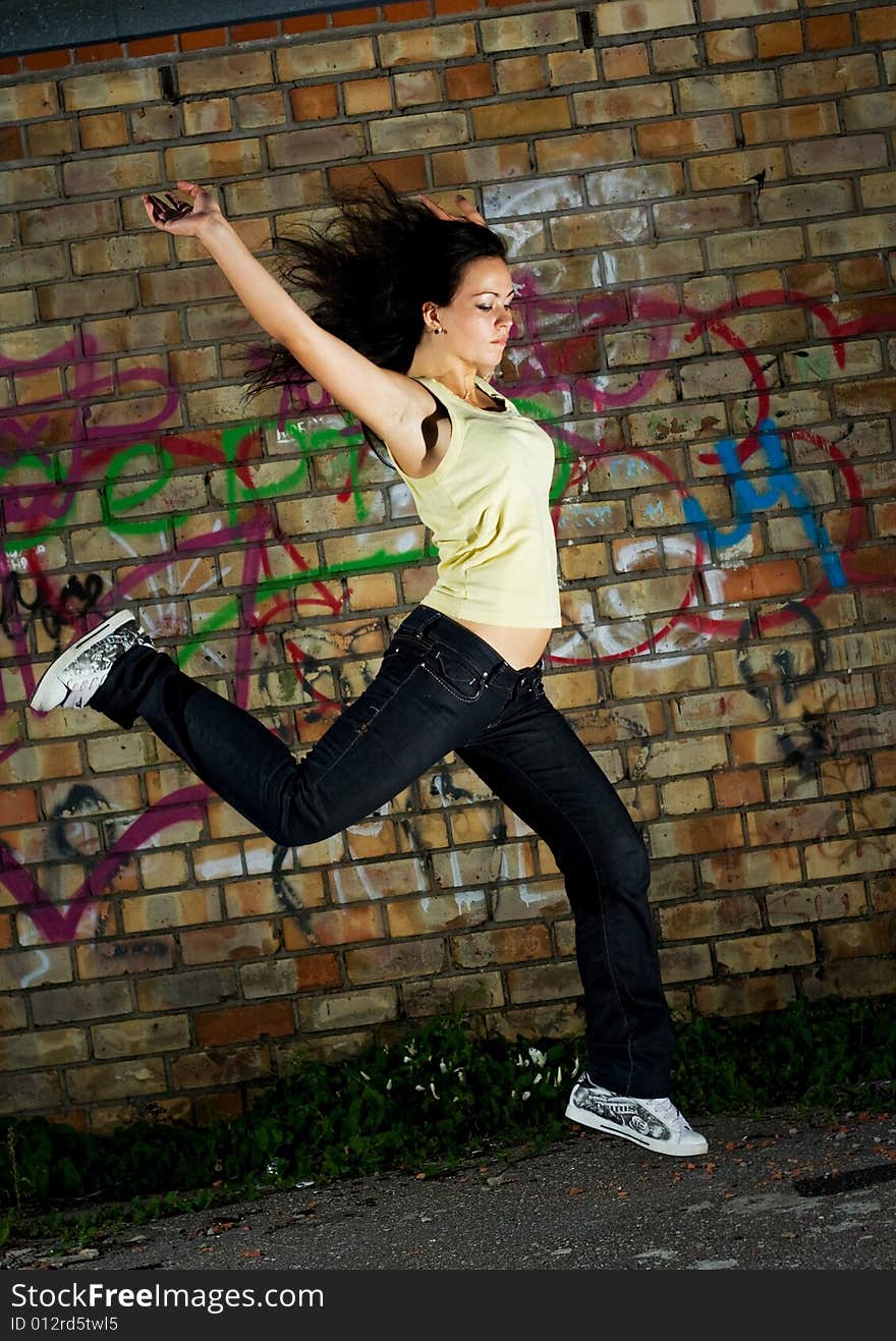 Young cute girl jumping against the wall. Young cute girl jumping against the wall.