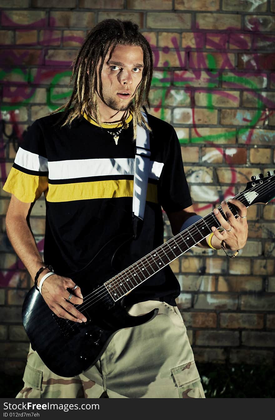 Young man holding his guitar. Young man holding his guitar.