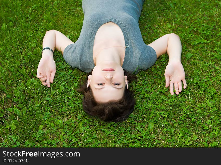 Beautiful girl lays on a green grass. Beautiful girl lays on a green grass