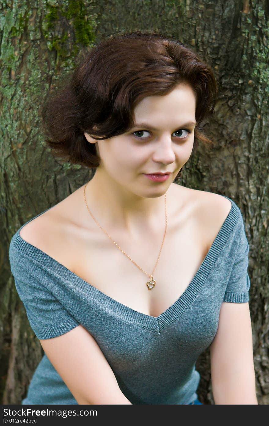 Portrait of the beautiful girl on a background of a tree trunk. Portrait of the beautiful girl on a background of a tree trunk