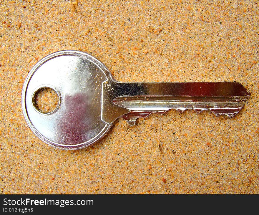 Photo of a key which lays on sand. Photo of a key which lays on sand.