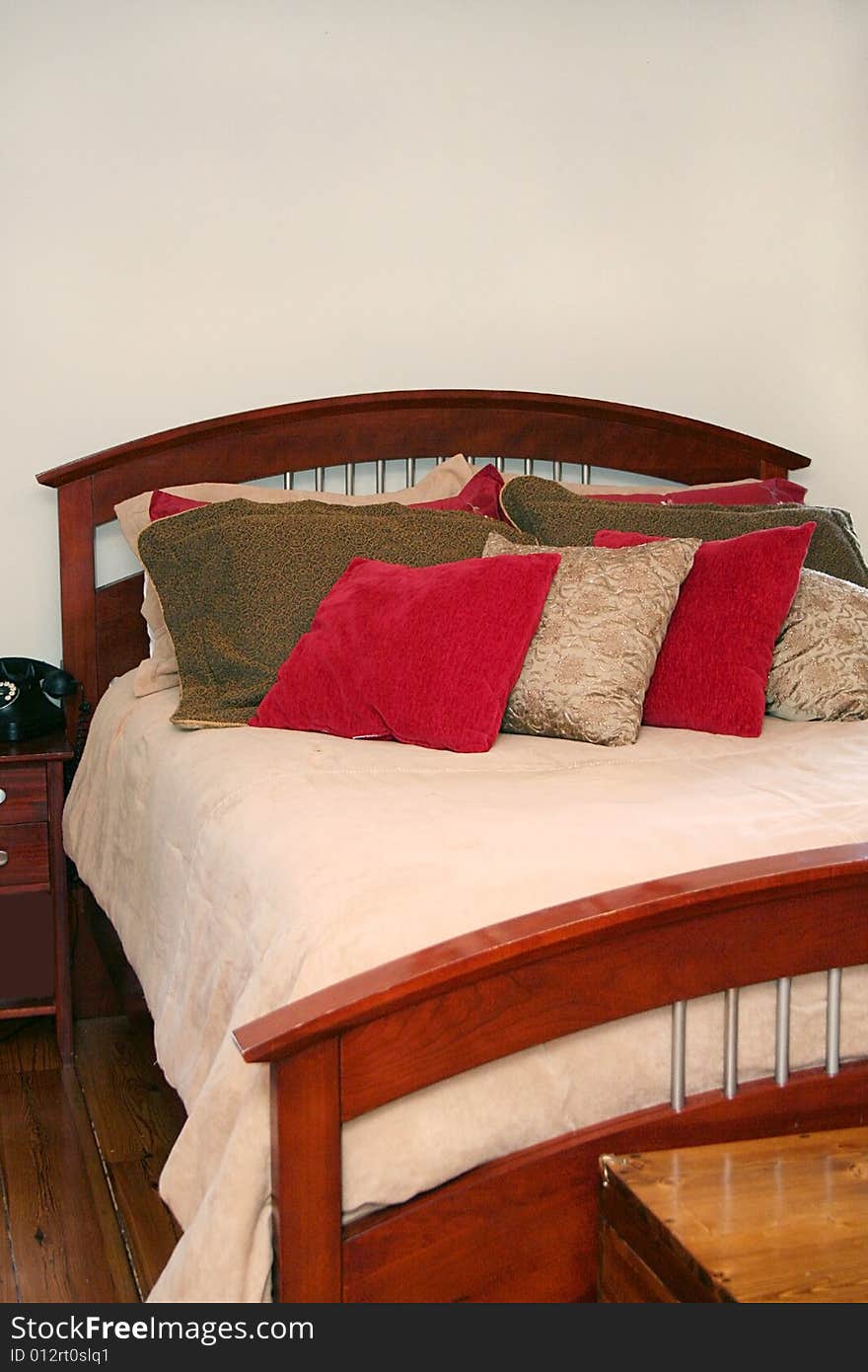 A bed is up against a blank wall with room for text and has many pillows on it. A bed is up against a blank wall with room for text and has many pillows on it.