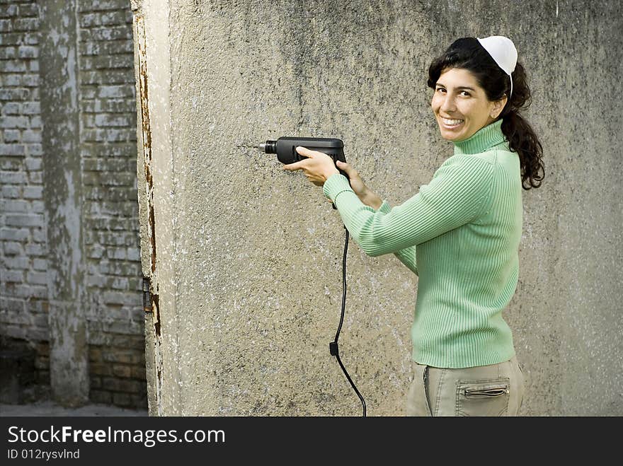 Smiling woman wearing with a mask on her head holding a drill. Horizontally framed photo. Smiling woman wearing with a mask on her head holding a drill. Horizontally framed photo.