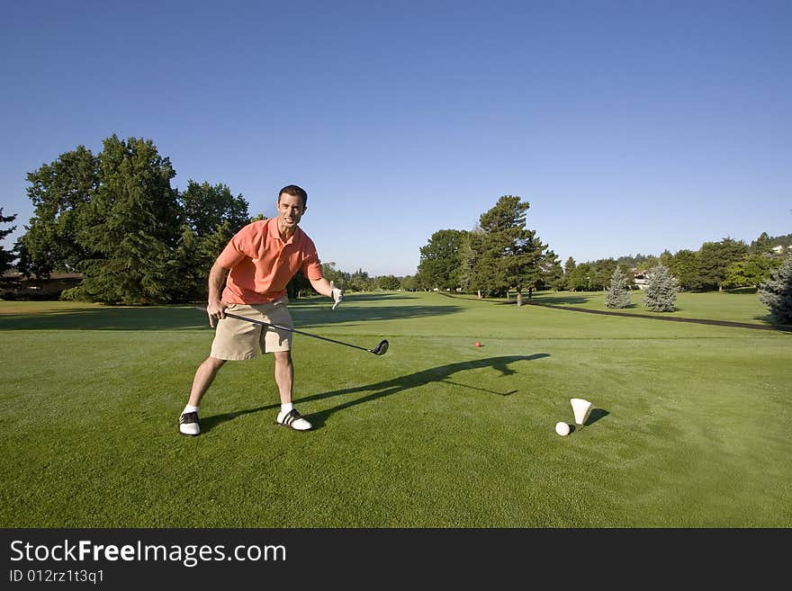 A man is standing on a golf course. He is holding a golf club and is looking angrily at the camera. Horizontally framed shot. A man is standing on a golf course. He is holding a golf club and is looking angrily at the camera. Horizontally framed shot.